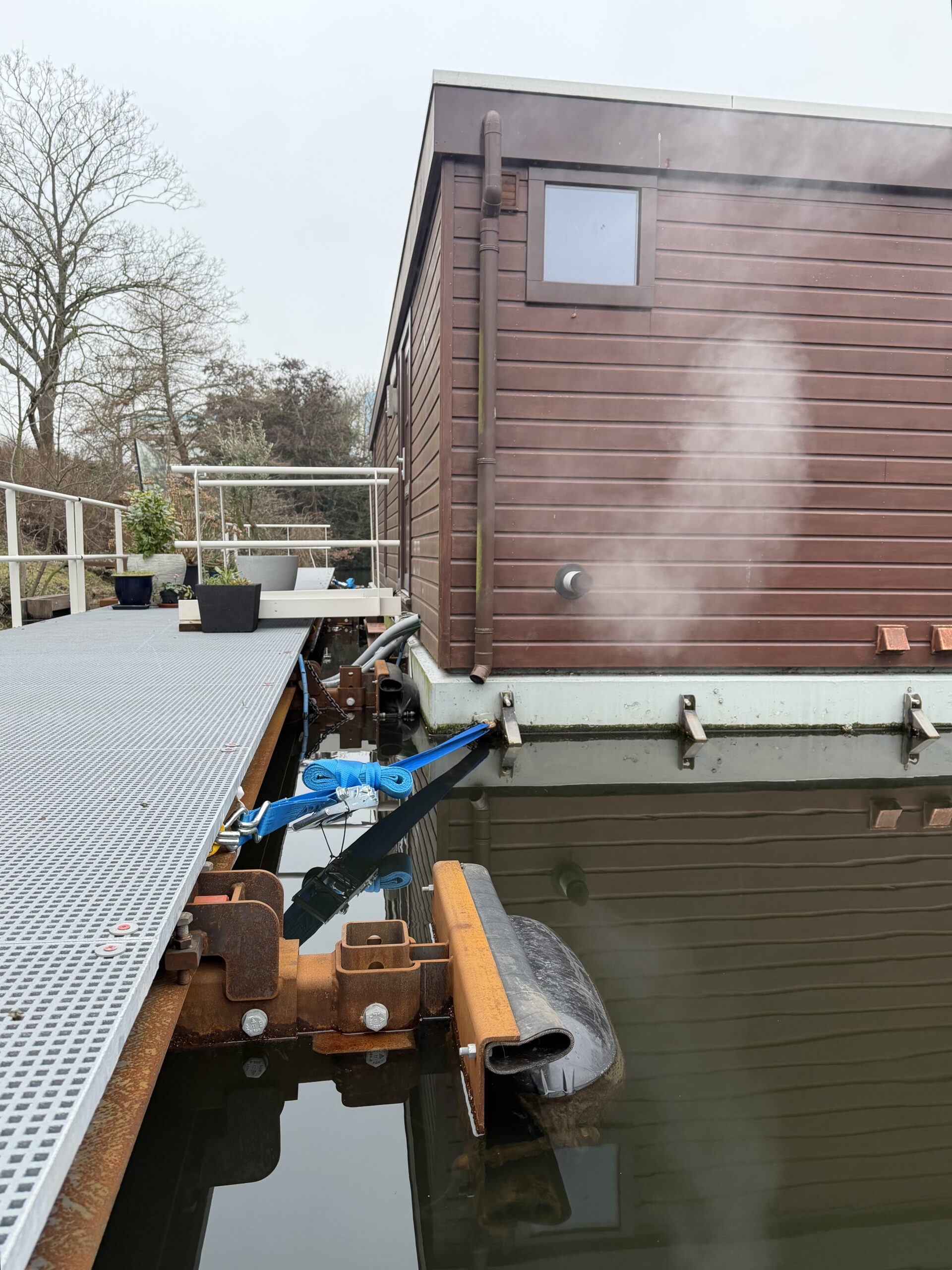 Bevestiging woonark aan de loopsteiger aan de Suezkade in de Den Haag