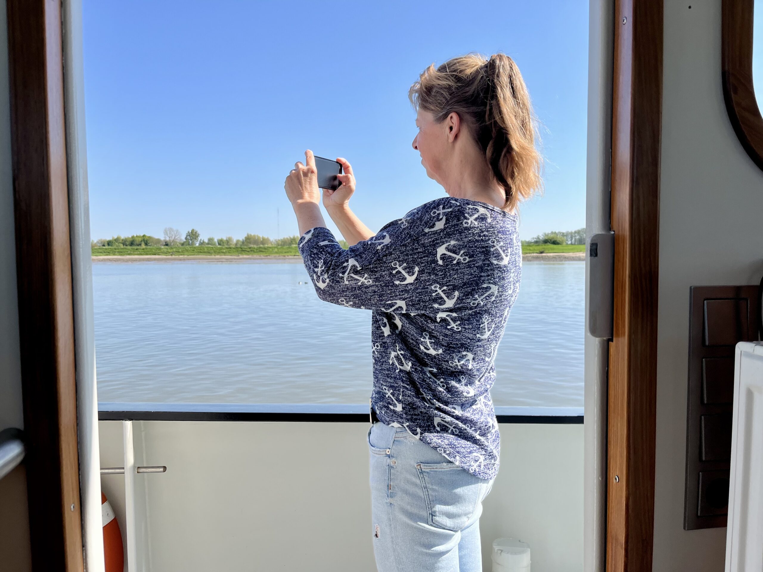 Anneke Robbertsen fotograferend aan dek op sleepboot Robbedoes