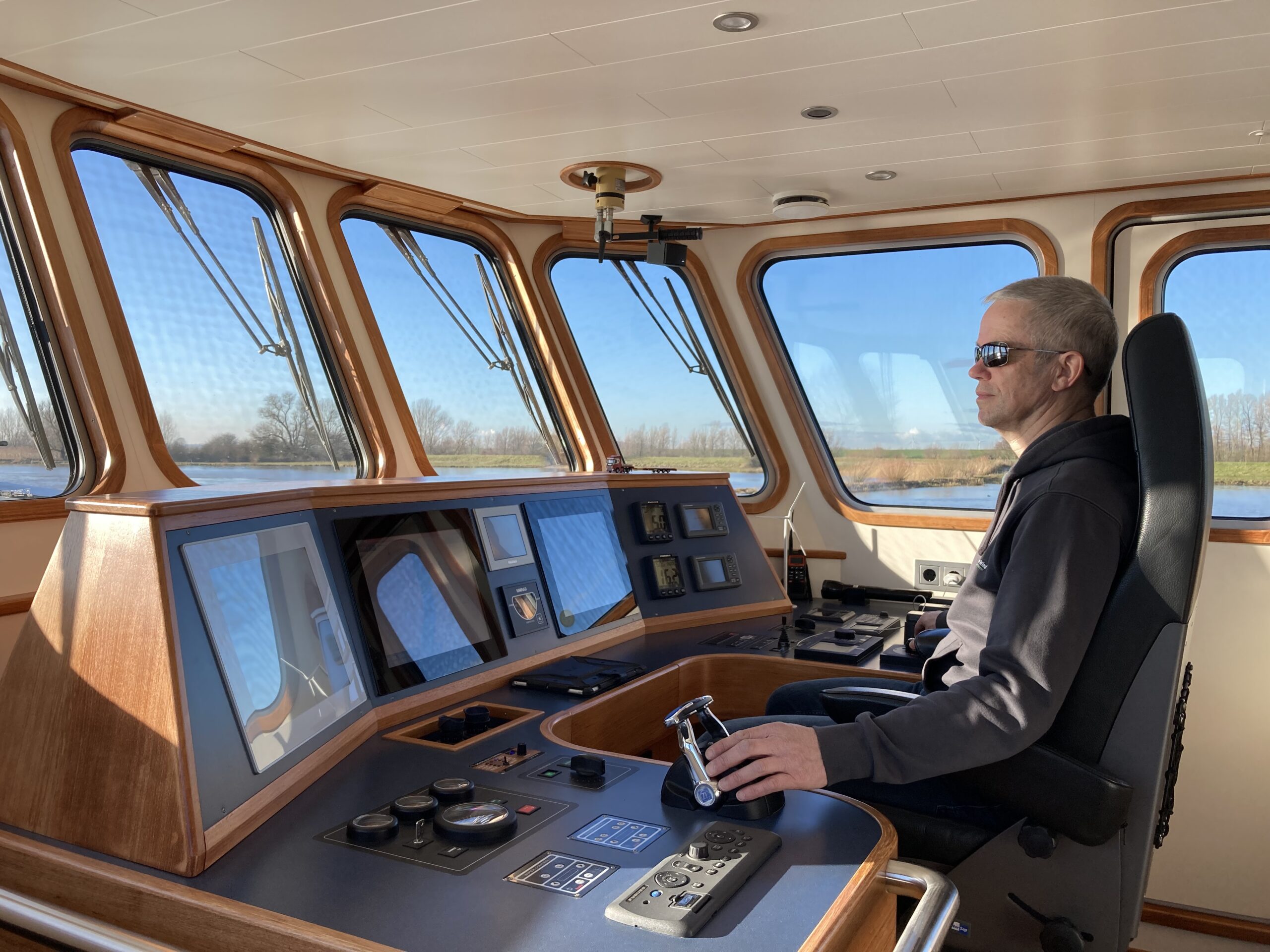 Wim Robbertsen achter roer stuurhut sleepboot Robbedoes